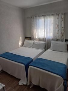 two beds sitting next to each other in a bedroom at Pousada Vilarejo de Minas in Itapeva