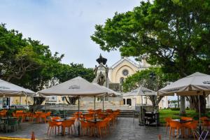 a group of tables with umbrellas in front of a building at Modern luxury Studio with Rooftop + parking in Panama City