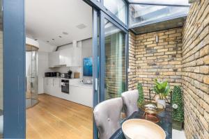 uma cozinha e sala de jantar com uma parede de tijolos em Trafalgar Square Arty Apartment em Londres