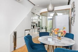 a kitchen and dining room with a table and blue chairs at Trafalgar Square Arty Apartment in London