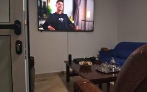 a living room with a tv with a man on it at CoWork & Stay Suites in Agadir