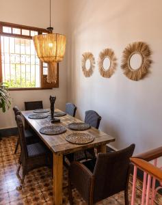 - une table à manger avec des chaises et des miroirs sur le mur dans l'établissement Casa Rosa - Alma Hotels, à Santa Marta