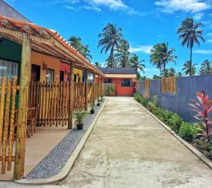 a house with a fence and a driveway at Villa Madu Milagres à 300 metros da praia in São Miguel dos Milagres