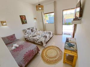 a living room with a bed and a couch at Villa Madu Milagres à 300 metros da praia in São Miguel dos Milagres