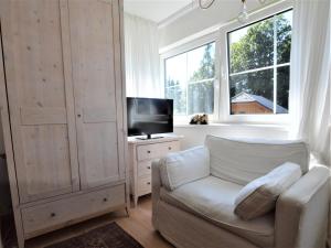 ein Wohnzimmer mit einem weißen Sofa und einem TV in der Unterkunft Landhaus Leitzinger OG1 in St. Wolfgang