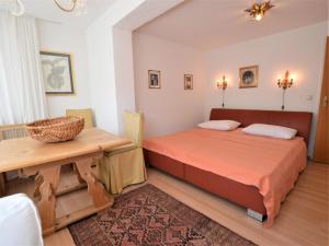 Schlafzimmer mit einem Bett und einem Holztisch in der Unterkunft Landhaus Leitzinger OG1 in St. Wolfgang