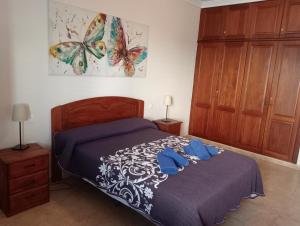 Un dormitorio con una cama con toallas azules. en Casa Carmen Dolores en Caleta de Sebo