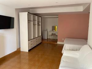 1 dormitorio con 1 cama y TV en una habitación en Pousada da Mariinha, en São Lourenço