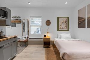 a white bedroom with a bed and a kitchen at Modern Home &Cozy in Lake Placid