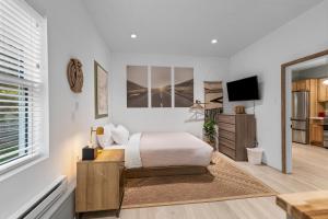 Habitación blanca con cama y TV en Modern Home &Cozy, en Lake Placid