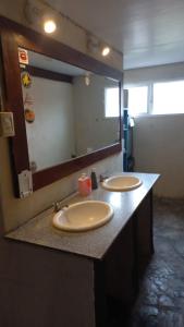uma casa de banho com 2 lavatórios e um espelho grande em La Maquinita Hostel em Mar del Plata