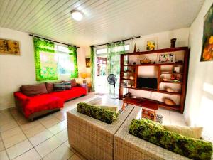 salon z kanapą i czerwoną kanapą w obiekcie TAHITI - Haumaru Beach Fare w mieście Mahina