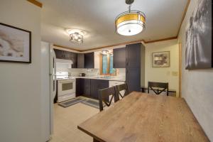 a kitchen and dining room with a wooden table and chairs at Hermantown Home with Decks, Grill and Hot Tub! in Hermantown