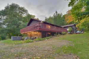 une grande maison avec une terrasse sur un champ dans l'établissement Hermantown Home with Decks, Grill and Hot Tub!, à Hermantown