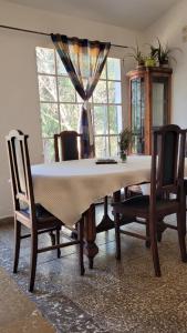 d'une salle à manger avec une table, des chaises et une fenêtre. dans l'établissement Hospedaje centro erks, à Capilla del Monte