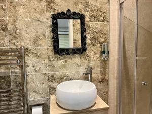 baño con lavabo y espejo en la pared en Ar-Rahman, 1 bed room and 1 Living room apartment en Kent