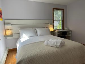 Un dormitorio con una cama blanca con una toalla. en Boston Single Family House - Super Quiet and Private en Boston