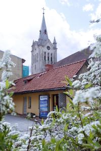 Una iglesia con una torre con un reloj. en Cēsu Namiņš, en Cēsis