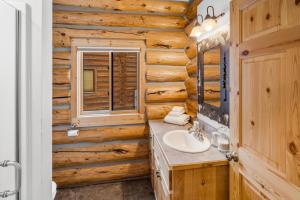 a bathroom in a log cabin with a sink and a window at King's Cabin in West Yellowstone +67 photos