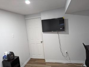 Habitación con TV de pantalla plana en la pared en Home of Pleasantness en Hamilton