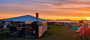 a group of tents with the sunset in the background at Camping Güino in Puerto Natales +11 photos