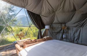 Bett in einem Zimmer mit einem großen Fenster in der Unterkunft Tammah Jackson Hole in Wilson