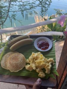 a plate of food with eggs and pancakes on a table at Borac Bay View in Borac