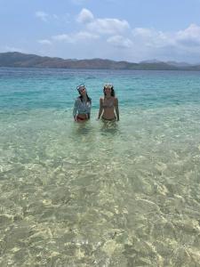 two women standing in the water in the ocean at Borac Bay View in Borac