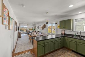 uma cozinha com armários verdes e uma sala de estar em Central Lake Placid Mountain Views em Lake Placid