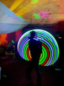 a man is standing in front of a large neon wheel at Free Spirit Hostel Guadalajara in Guadalajara