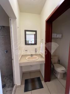 a bathroom with a sink and a toilet and a mirror at Diamante Dos Joyas Del Mar Bahia de Kino in Bahía Kino