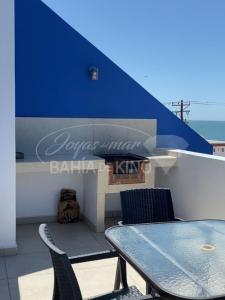 a table and chairs on a balcony with a blue wall at Diamante Dos Joyas Del Mar Bahia de Kino in Bahía Kino