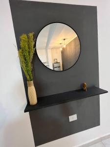un miroir sur un mur avec un vase sur une étagère dans l'établissement Ideal para 4 personas o familia, à Resistencia