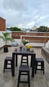 a black table and chairs on a rooftop patio at Alojamiento completo en el centro in Veracruz