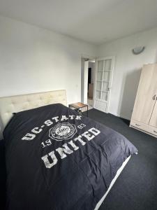 - une chambre avec un lit doté d'une couette noire dans l'établissement PR2e, au Blanc-Mesnil