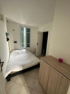 - une petite chambre avec un lit et une fenêtre dans l'établissement PR2e, au Blanc-Mesnil