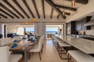 a kitchen and dining room with a long table and chairs at Seaside Serenity A Luxurious Coronado Home in Cabo San Lucas