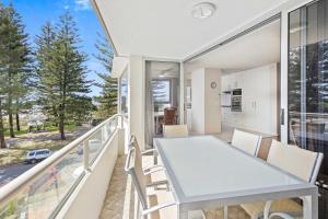 a balcony with a white table and chairs on it at Ambassador Beachfront Apartments - Hosted by Burleigh Letting in Gold Coast