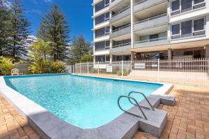a swimming pool in front of a apartment building at Ambassador Beachfront Apartments - Hosted by Burleigh Letting in Gold Coast