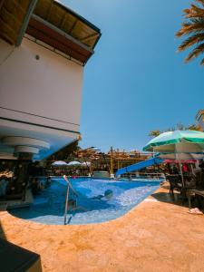 ein großer Pool mit Rutsche und Sonnenschirmen in der Unterkunft Hosteria La Medusa in Cocorná