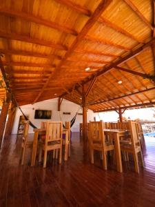 grupa drewnianych stołów i krzeseł pod dachem w obiekcie Hosteria La Medusa w mieście Cocorná
