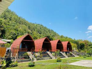 a row of huts with a mountain in the background at D’Taman cabin Kintamani in Kubupenlokan +15 photos