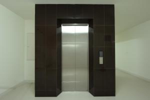 a elevator in a restroom with brown tiles at Sawairiang Place in Nakhon Ratchasima