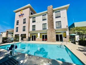 a hotel with a swimming pool in front of a building at Comfort Suites Augusta Riverwatch in Augusta