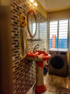 a bathroom with a red sink and a mirror at Asma-ul-husna apartment in Rājshāhi