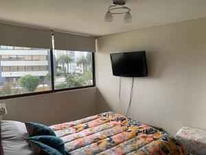 a bedroom with a bed and a flat screen tv at Relajante y Confortable Departamento Frente al Mar in Viña del Mar +24 photos