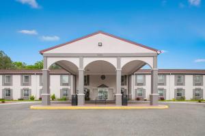 a large white building with an arch in front of it at Red Roof Inn Dahlgren - Naval Base in Dahlgren