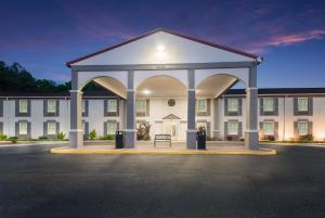 a large white building with a bench in front of it at Red Roof Inn Dahlgren - Naval Base in Dahlgren