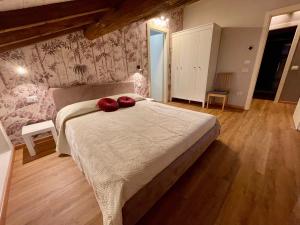 a bedroom with a bed with two red pillows on it at Domus 44 Apartments in Verona