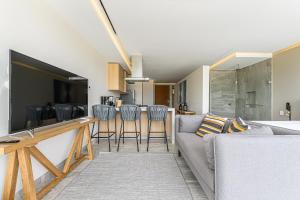 a living room with a couch and a table with chairs at Lumina at Cardinal San José del Cabo in San José del Cabo